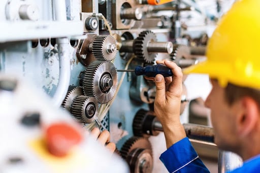 Millwright inspecting industrial machinery