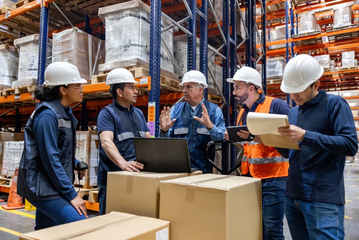 Manufacturing team coordinating work in a warehouse.