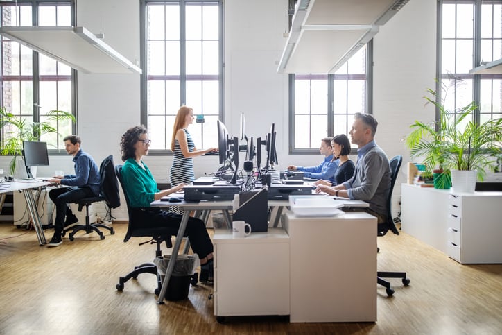 hot desking essentials - stand up desk in pod of workers